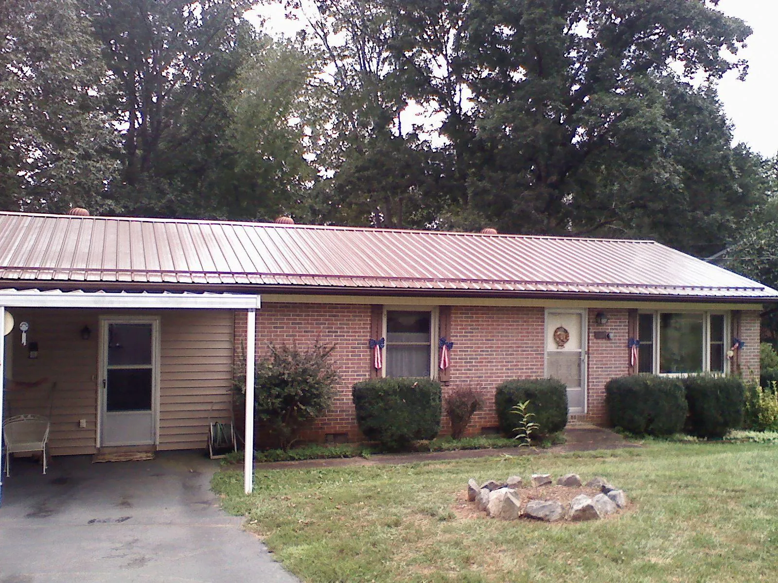Bronze metal roof and carport on a brick ranch home — Roof Repair work by our crew in Skaneateles